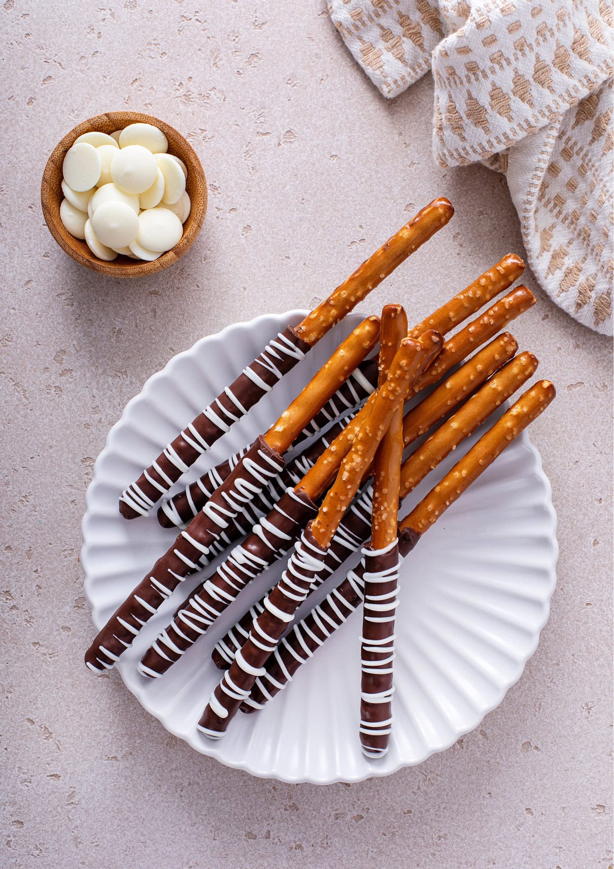 A plate stacked with chocolate covered pretzel rods.