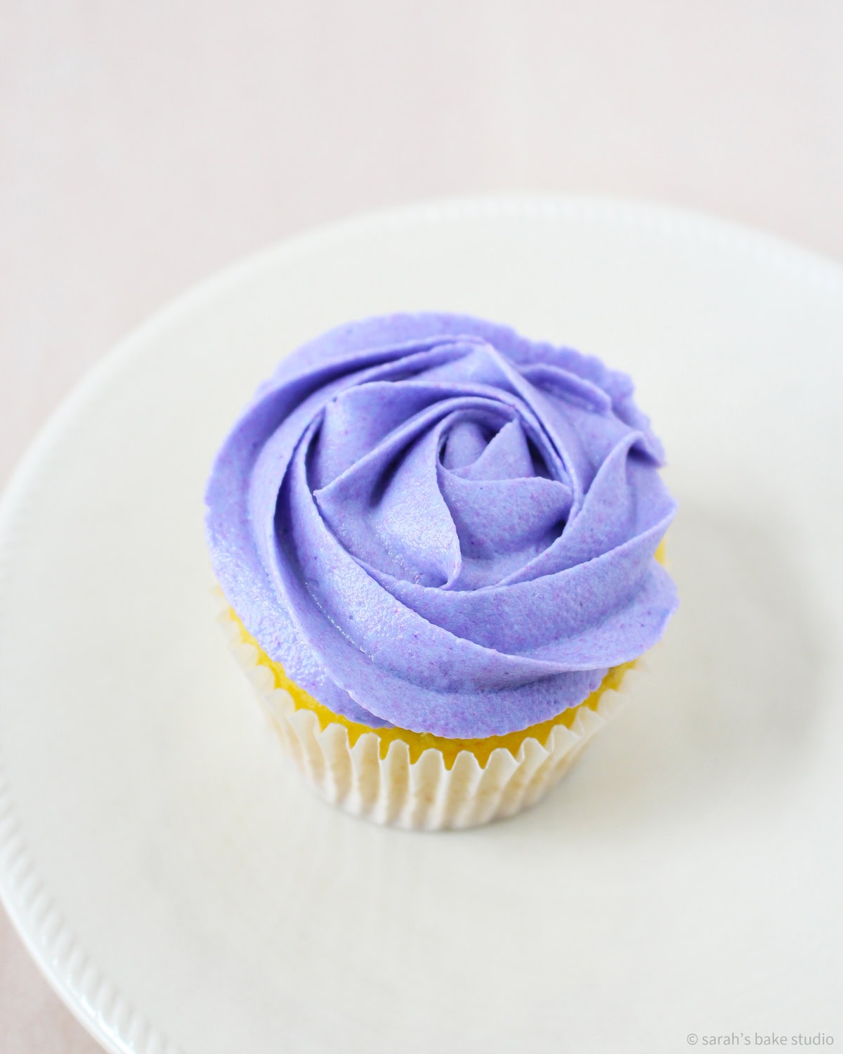 A purple rose frosted cupcake.