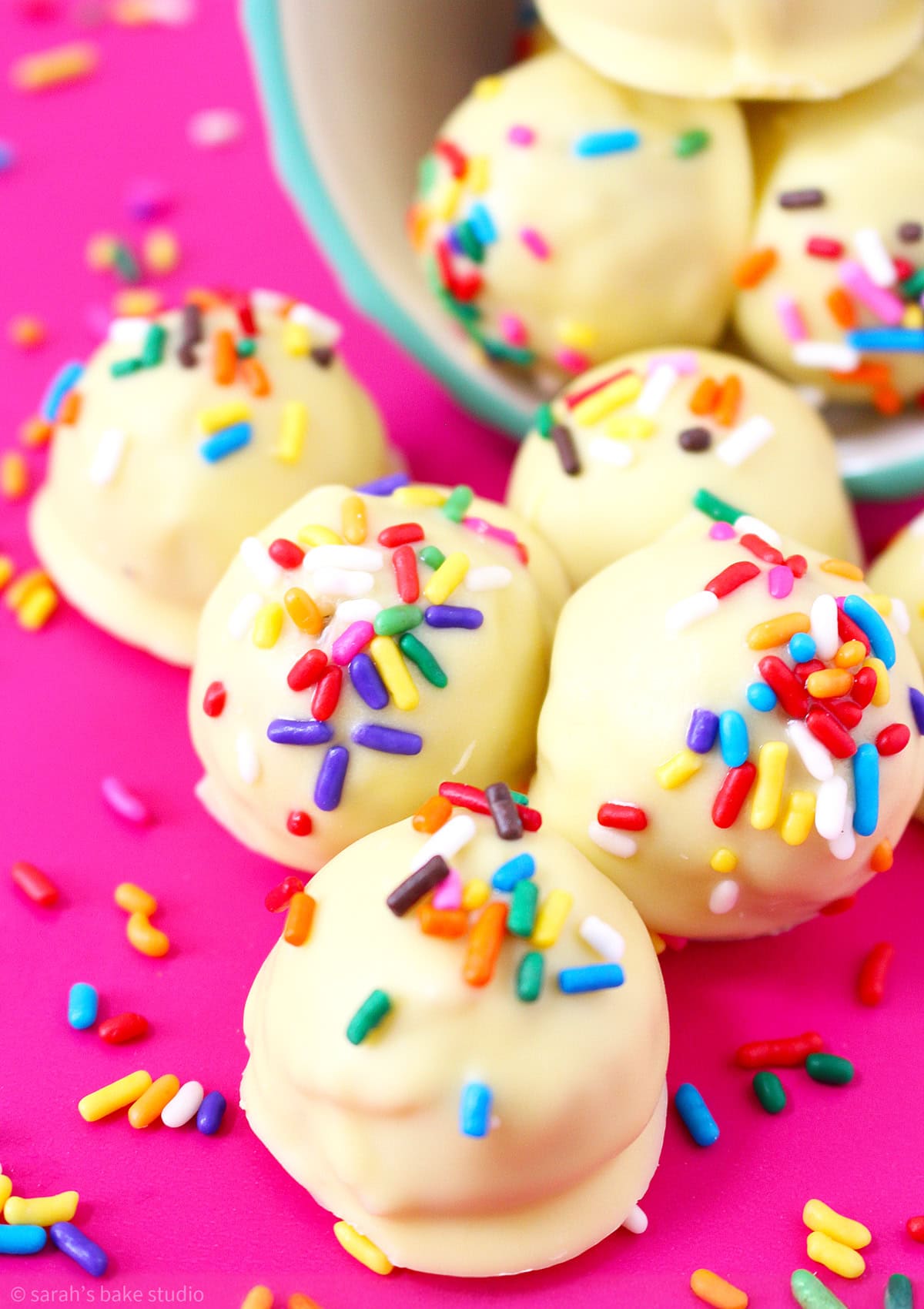 Birthday Cake Oreo Truffles spilling out of a bowl.