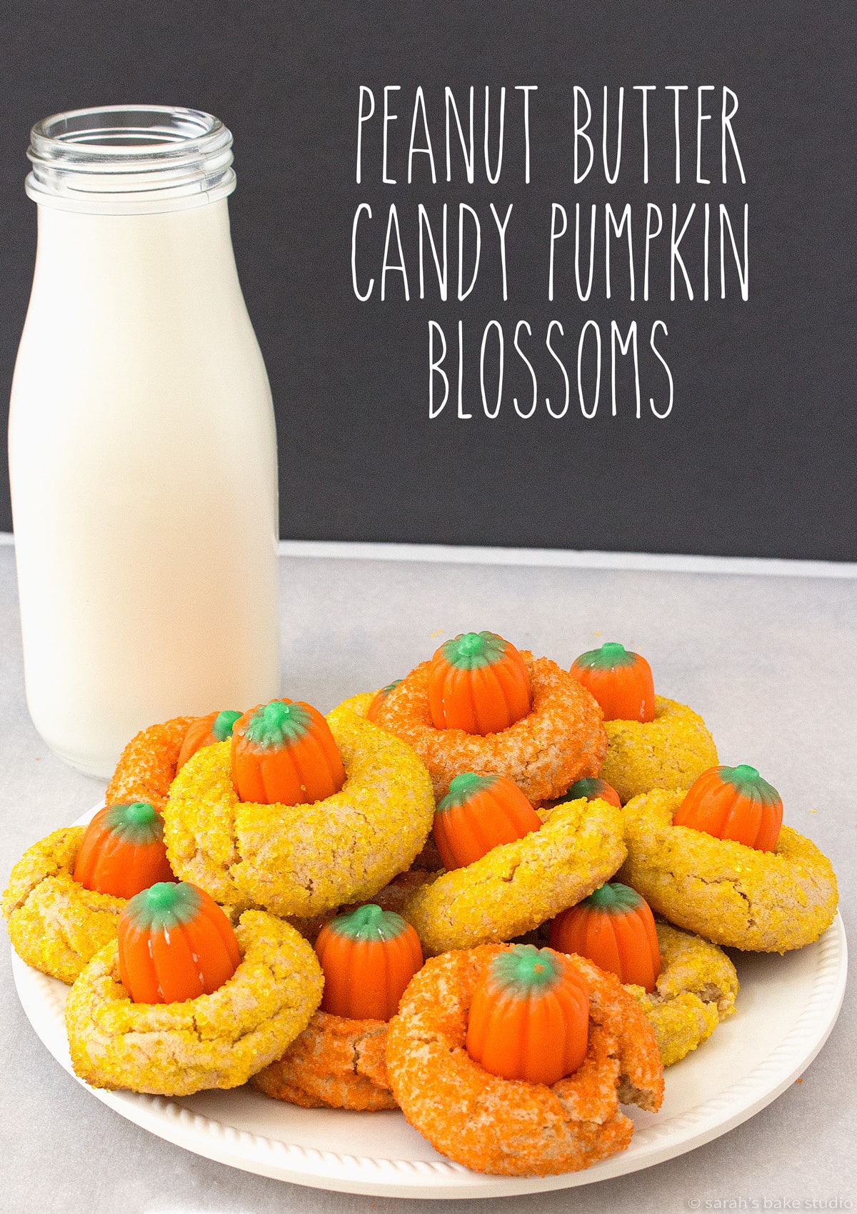 A plate of Peanut Butter Candy Pumpkin Blossoms with a glass of milk.