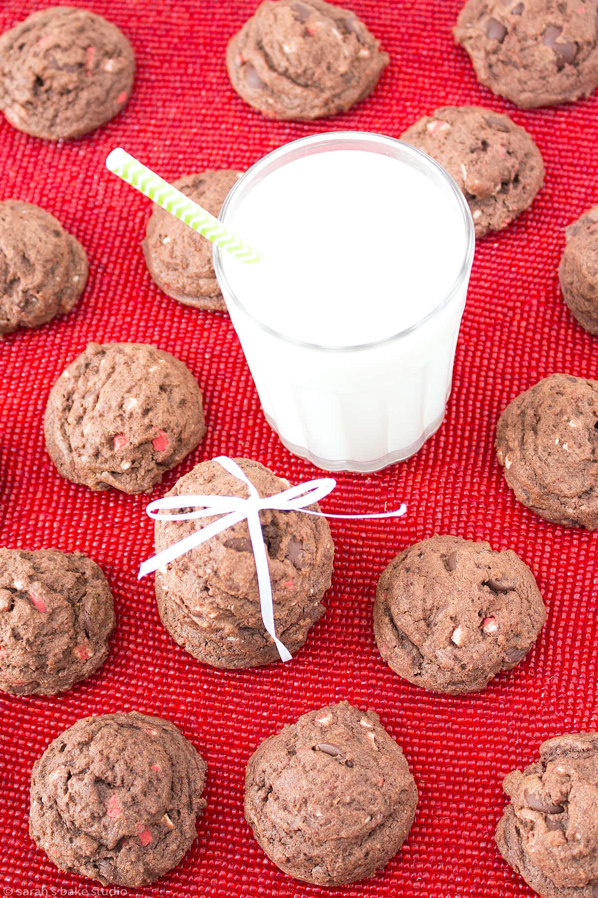 a flatlay of triple chocolate peppermint cookies with a glass of milk.