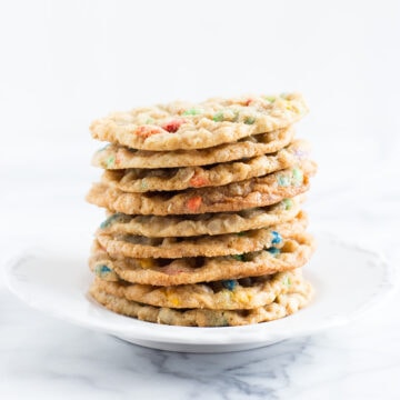 A white plate stacked with Crispy Sunflower Cookies.