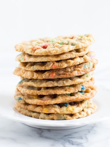 A white plate stacked with Crispy Sunflower Cookies.