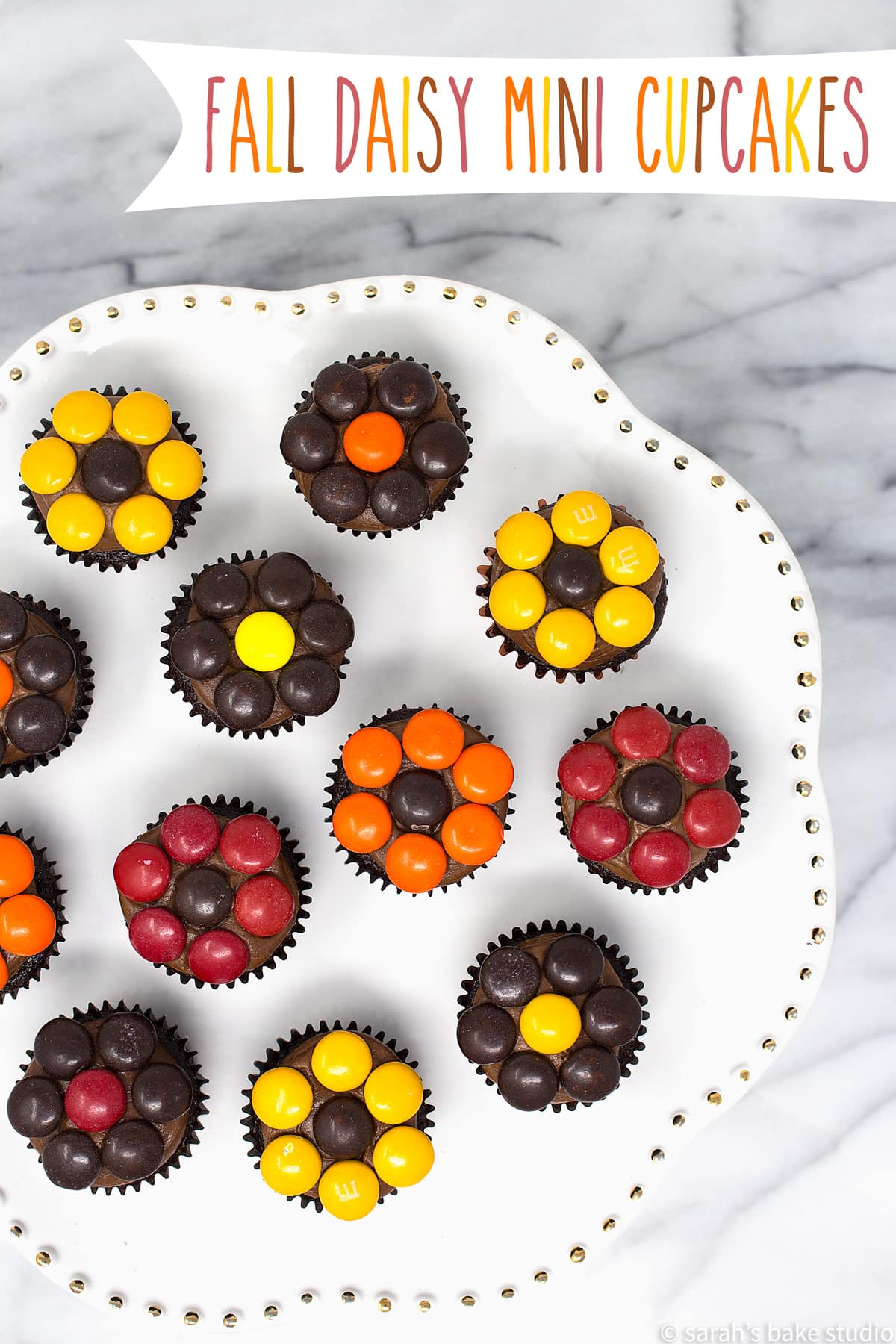 A cake plate with fall daisy mini cupcakes on display.