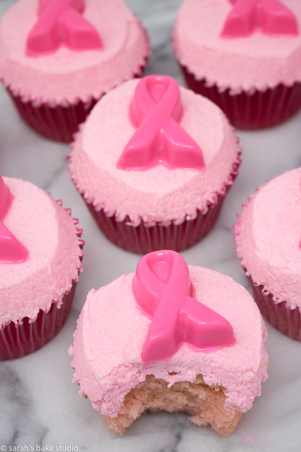 Pink Ribbon Pink Velvet Cupcakes – pink velvet cupcakes crowned with pink buttercream and adorned with white chocolate pink ribbons; a pinkalicous cupcake in honor of Breast Cancer Awareness Month.