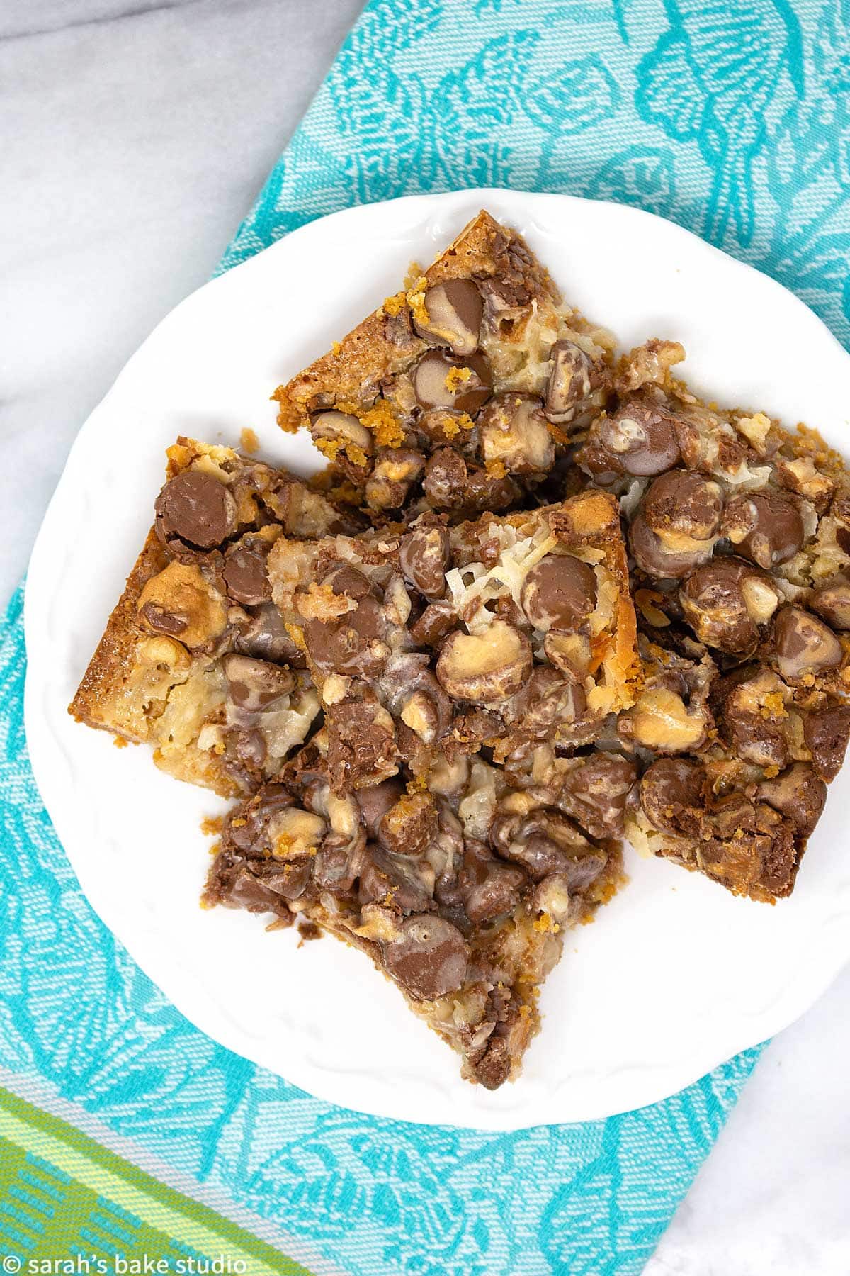 Malted Hello Dolly Bars - a delish graham cracker crust dressed to the nines with milk chocolate chips, coconut flakes, walnut pieces, and chopped Whoppers; it's a scrumptious whopper of a dessert bar.