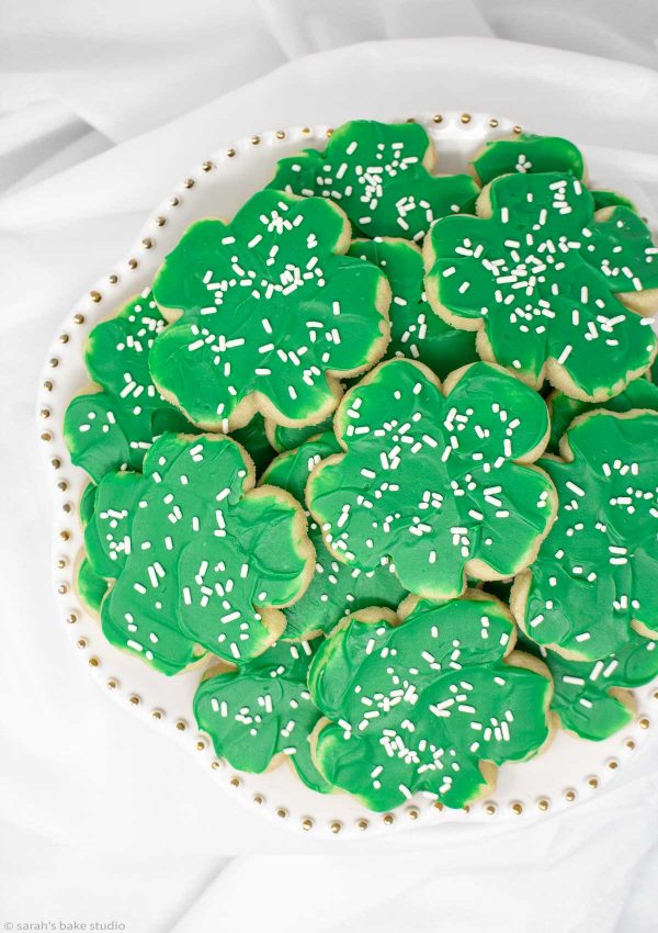 Shamrock Cookies - magically delicious shamrock sugar cookies frosted with melted green chocolate and topped with lucky white sprinkles for VERY St. Patrick’s Day cookies.