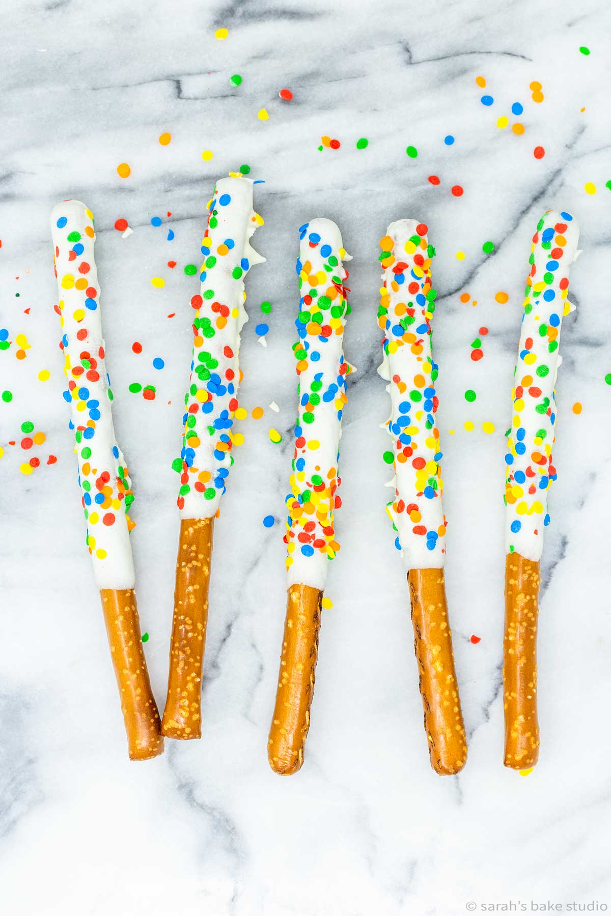 Rainbow Pretzel Wands - pretzel rods dipped in white chocolate and sprinkled with rainbow happiness; a magically delicious sweet and salty dessert.